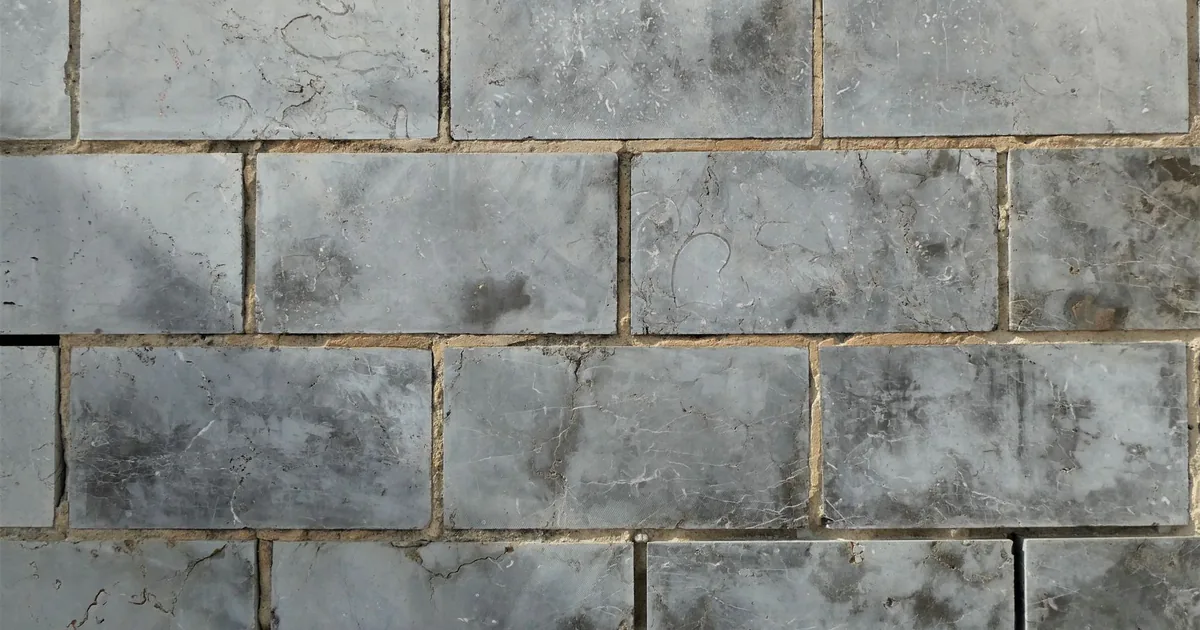 Równe spoiny między ceramicznymi płytkami ściennymi wypełnione fugą cementową