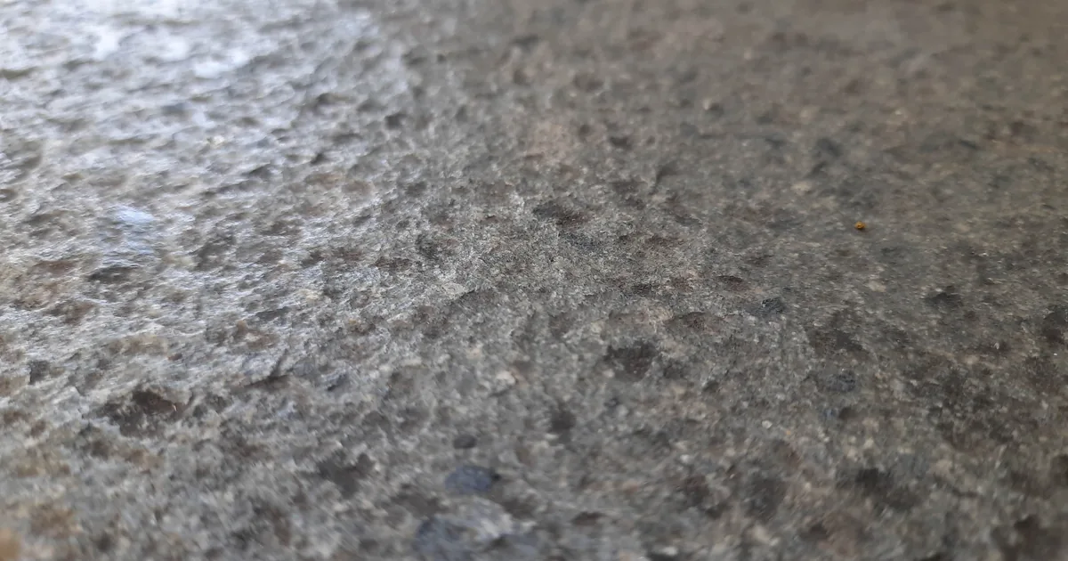 Zbliżenie na szarą, chropowatą powierzchnię betonowej posadzki bez powłoki